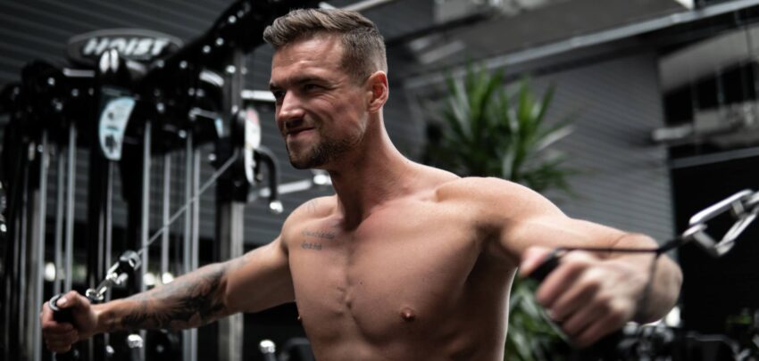 a man performing a chest fly on a dual cable machine at the gym