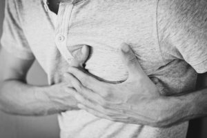 a man clutching his chest muscles