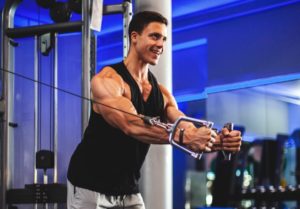a man performing a high to low cable fly crossover on a dual cable machine at the gym